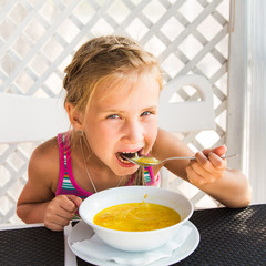 Cute child eating soup