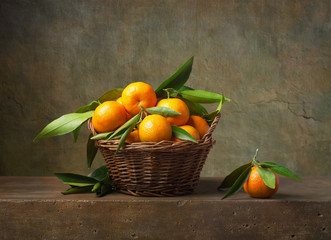 Still life with tangerines in a basket on the table