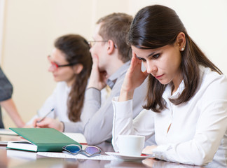 Tired business woman with headache at seminar