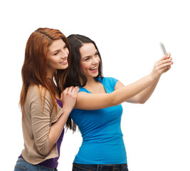 two smiling teenagers with smartphone