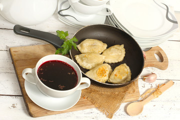 homemade pierogi (ravioli)  and clear red borscht 