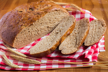 Sliced bread on tablecloth with stalks