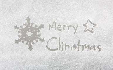 Snow on the frozen window with word " Merry Christmas " and snow