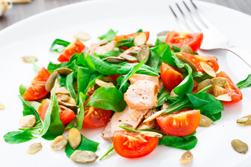 Salad with arugula, salmon and cherry tomato