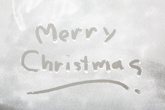 Snow on the frozen window with word " Merry Christmas "