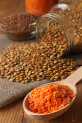 Red lentils in wooden spoon with green lentils