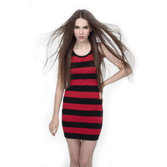 Beautiful woman in striped dress with long hair standing