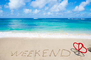Sign "Weekend" with hearts on the beach