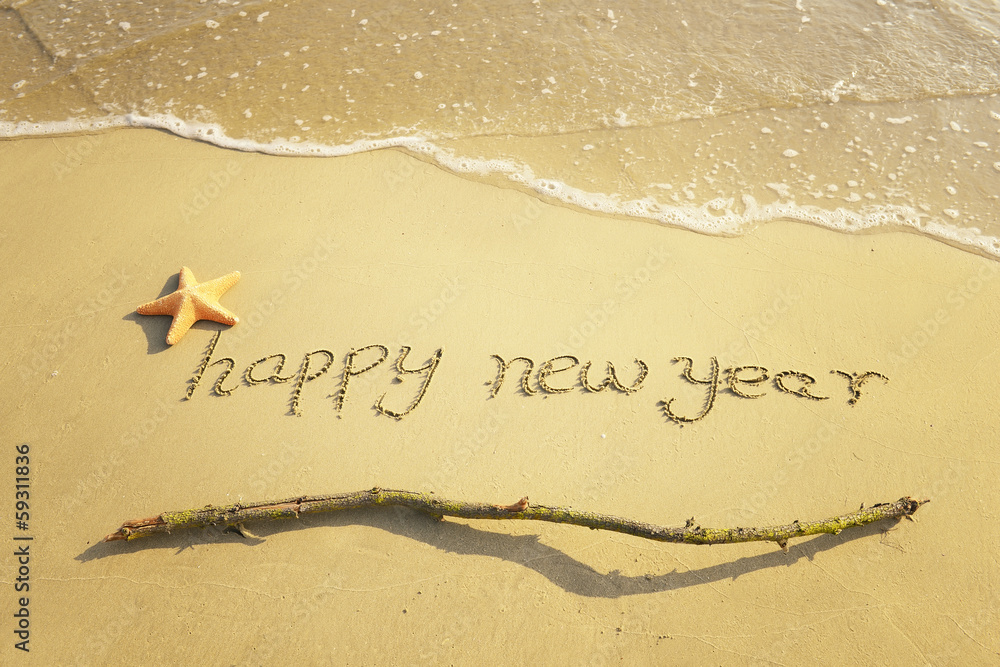 Wall mural happy new year message on the sand beach