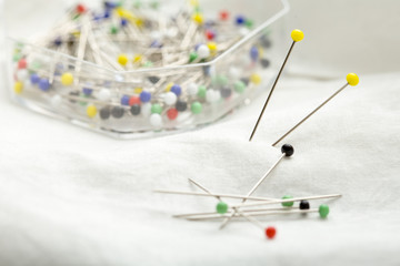 Fototapeta na wymiar sewing needles on a white cloth