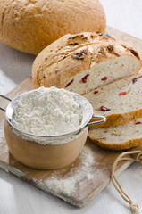 Bread and flour on wooden table.