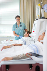 Nurse Standing By Patient Undergoing Renal Dialysis