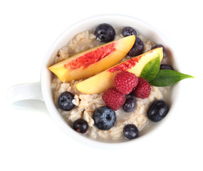 Oatmeal in cup with berries isolated on white
