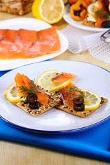 Salmon sandwiches on plate  on wooden table close-up