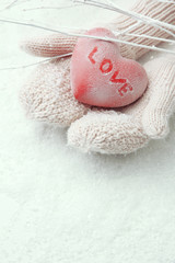 Female hands in mittens with red heart, close-up
