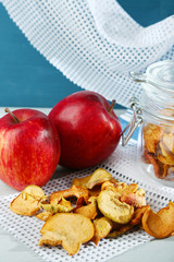 Dried apples in glass jar, on color wooden background