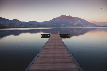 a long pier leading out onto the lake, sunrise on lake, long way