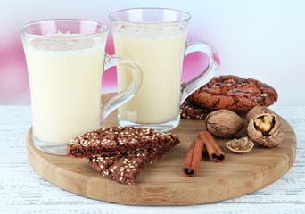 Cups of eggnog with cinnamon and cookies