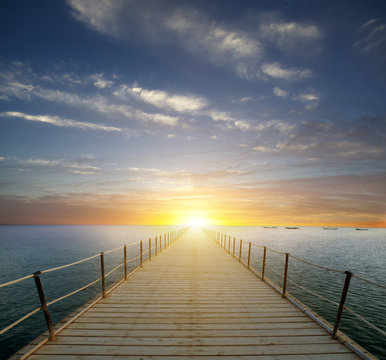 Fototapeta Sunset over the sea. Pier on the foreground