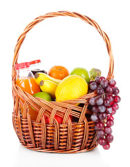 Different fruits in wicker basket with juice isolated on white