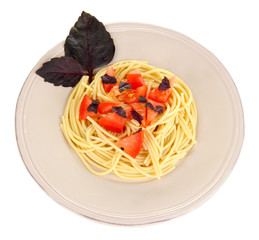 Spaghetti with tomatoes and basil leaves isolated on white