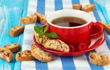 Cup of tea with cookies and raspberries on table close-up