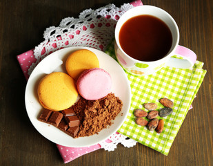 Cocoa in cup with sweets and cocoa powder