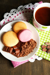 Cocoa in cup with sweets and cocoa powder