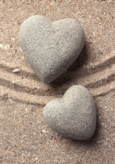 Grey zen stone in shape of heart, on sand background