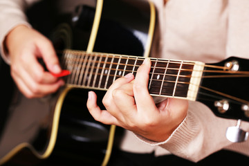 Fototapeta na wymiar Gitara akustyczna w rękach kobiet, zbliżenie