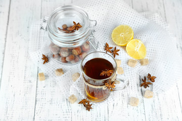 Hot beverage in glass cup with fruits and spices,