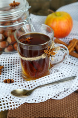 Hot beverage in glass cup with fruits and spices,