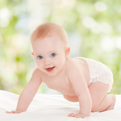 Cute baby with beautiful blue eyes on the white bed