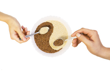 Eastern cuisine - man and woman hold spoons with sesame seeds in