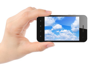 Woman hand holds smart phone with sky on white background