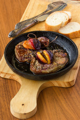 Lamb being fried with plums