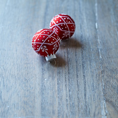 Two red christmas balls on a wooden background