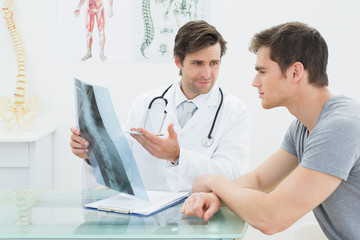 Male doctor explaining spine x-ray to patient