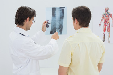 Obraz premium Male doctor explaining spine x-ray to patient