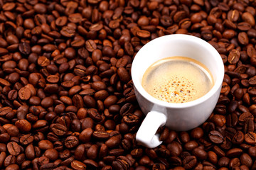 Cup of coffee on coffee beans