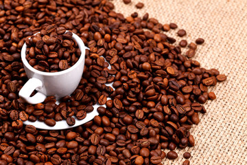 Coffee beans and cup on burlap