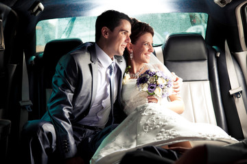 couple sitting on backseat of the car and looking out of window