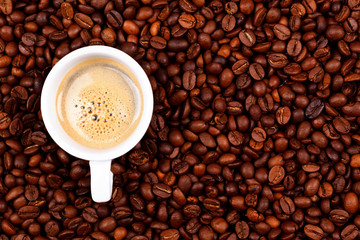 Cup of coffee on coffee beans