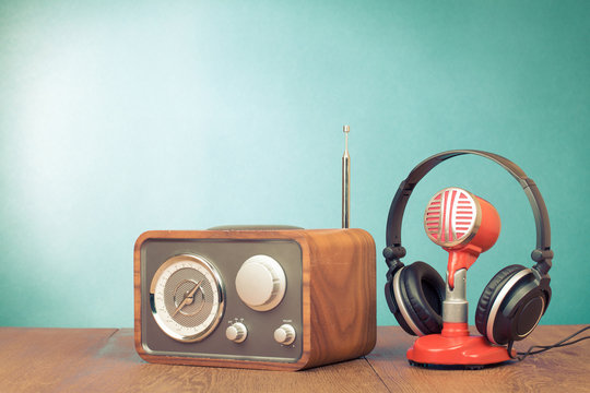 Retro radio, red microphone, headphones on table old style photo