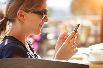 Happy woman reading smart phone text over wifi