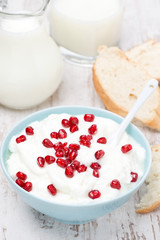 homemade yogurt with pomegranate, milk and bread for breakfast