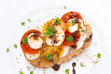 piece of ciabatta with mozzarella, balsamic, colorful tomatoes