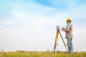 Surveyor engineer making measure on the field with tablet pc - obrazy, fototapety, plakaty