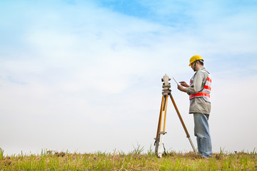 Surveyor engineer making measure on the field with tablet pc