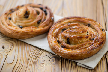 Two french sweet spiral buns on a rustic wooden table